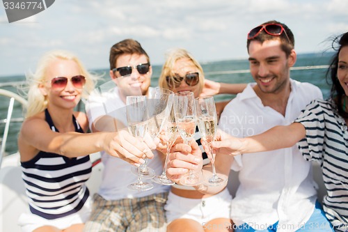 Image of happy friends with glasses of champagne on yacht