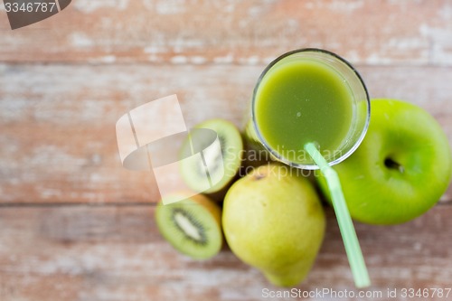 Image of close up of fresh green juice and fruits on table
