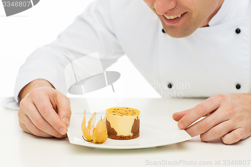 Image of close up of happy male chef cook with dessert