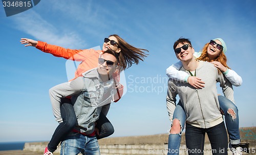 Image of happy teenage friends having fun outdoors