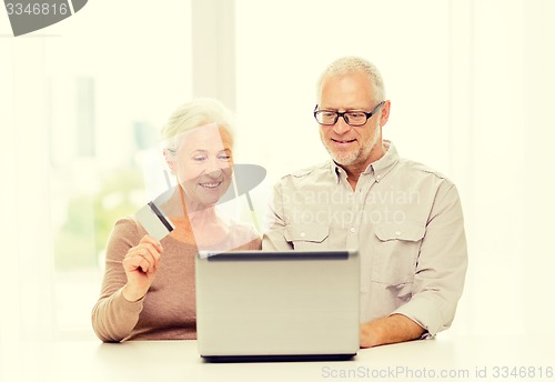 Image of happy senior couple with laptop and credit card