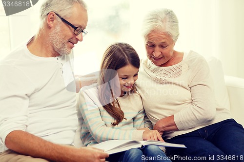 Image of smiling family with book at home