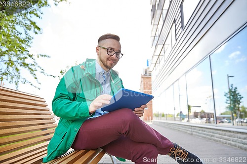 Image of happy young hipster man with tablet pc and bike