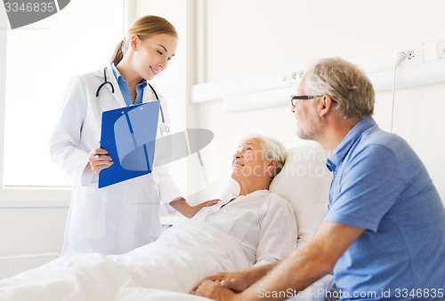 Image of senior woman and doctor with clipboard at hospital