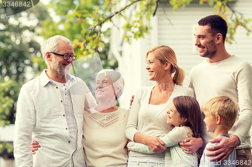 Image of happy family in front of house outdoors