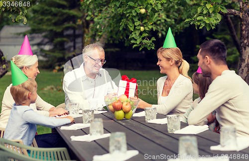 Image of happy family having holiday dinner outdoors