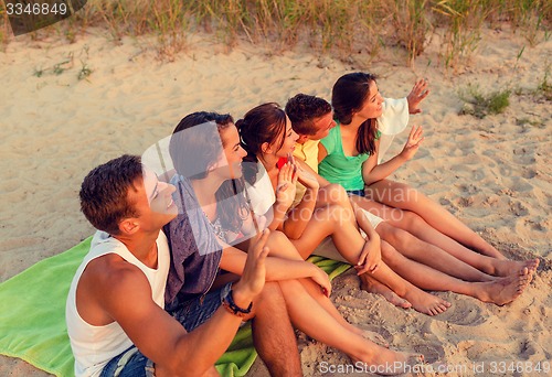 Image of smiling friends in sunglasses on summer beach