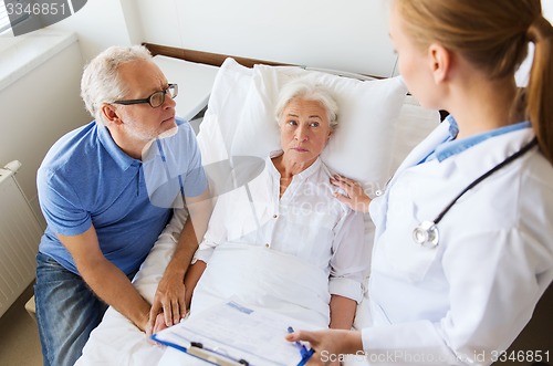 Image of senior woman and doctor with clipboard at hospital