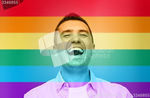 Image of laughing man over rainbow flag stripes background