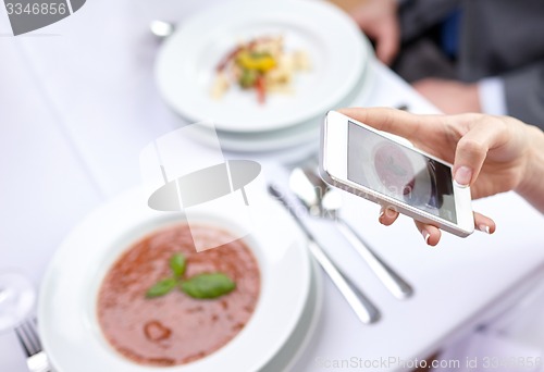 Image of close up of couple with smartphones at restaurant