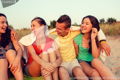 Image of smiling friends in sunglasses on summer beach