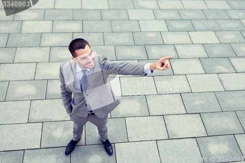 Image of young smiling businessman outdoors from top