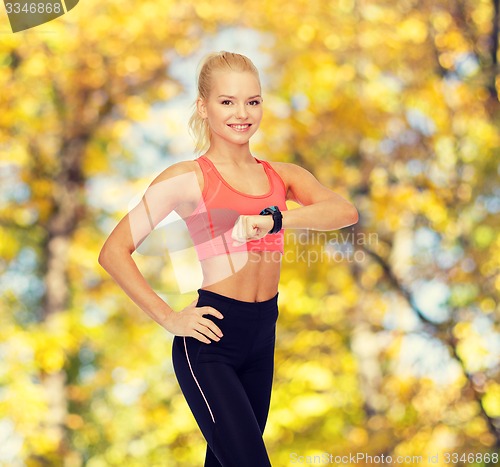 Image of smiling woman with heart rate monitor on hand