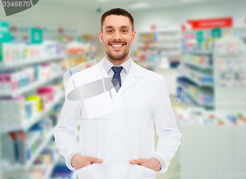 Image of smiling male pharmacist in white coat at drugstore