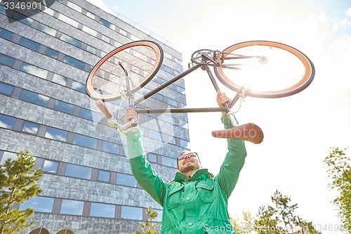 Image of young hipster man rising fixed gear bike in city