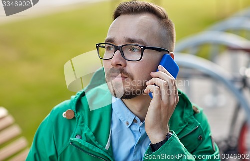 Image of young hipster man calling on smartphone