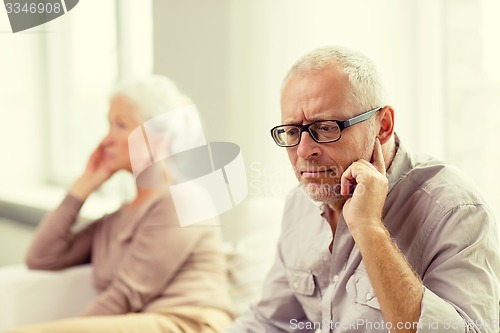 Image of senior couple sitting on sofa at home