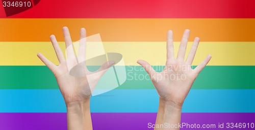 Image of palms of human hands thumbs up over rainbow