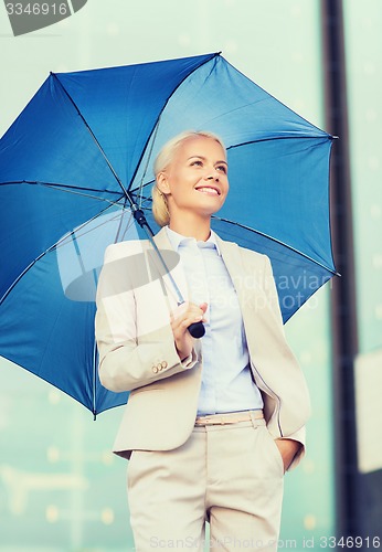 Image of young smiling businesswoman with umbrella outdoors