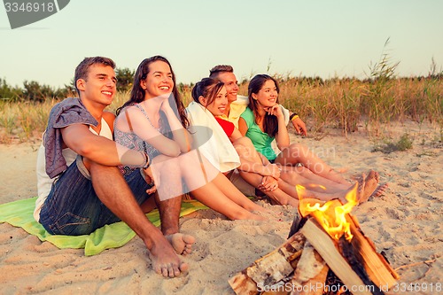 Image of smiling friends in sunglasses on summer beach