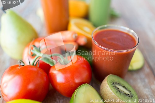 Image of close up of fresh juice glass and fruits on table