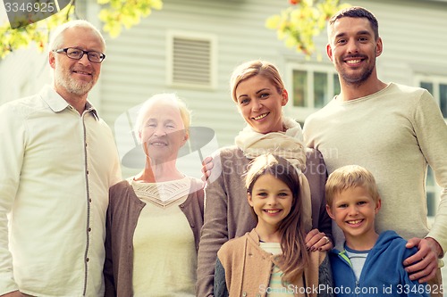 Image of happy family in front of house outdoors