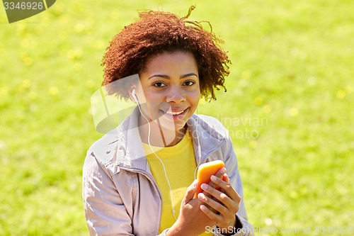 Image of happy african woman with smartphone and earphones