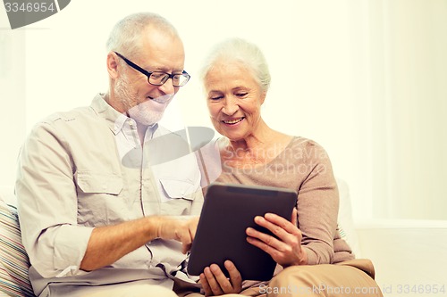 Image of happy senior couple with tablet pc at home