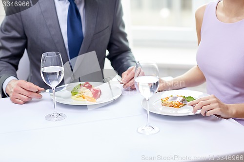 Image of close up of couple eating appetizers at restaurant