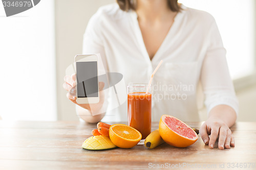 Image of close up of woman hands with smartphone fruits