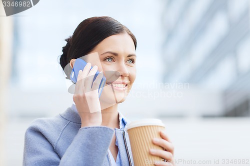 Image of smiling woman with coffee calling on smartphone