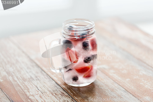 Image of close up of fruit water in glass mug on table