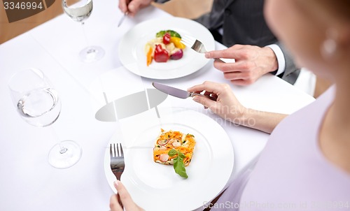 Image of close up of couple eating appetizers at restaurant
