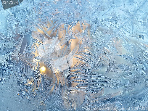 Image of Ice pattern and sunlight on winter glass