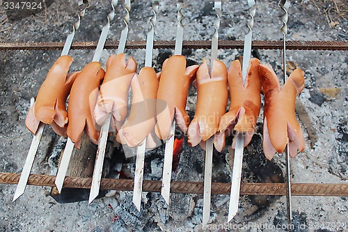 Image of sausage roasting on the fire