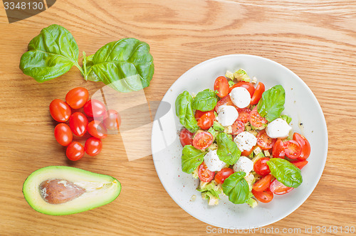 Image of Top view to the salad with avocado and tomatoes