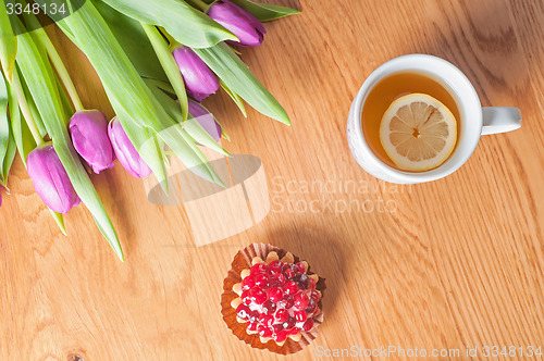 Image of Violet tulips, cake and tea on the wood