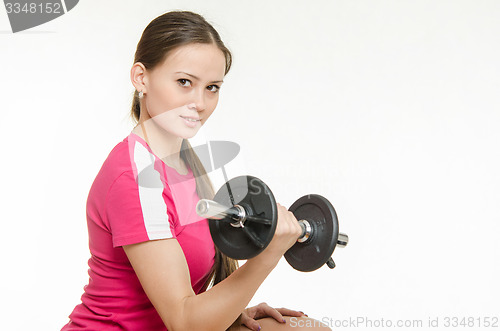 Image of Athlete swings dumbbells muscles of the right hand