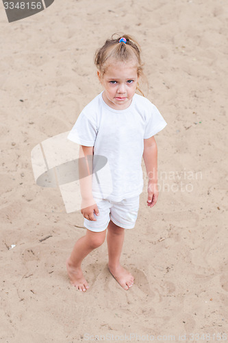 Image of Upset girl standing on the sand
