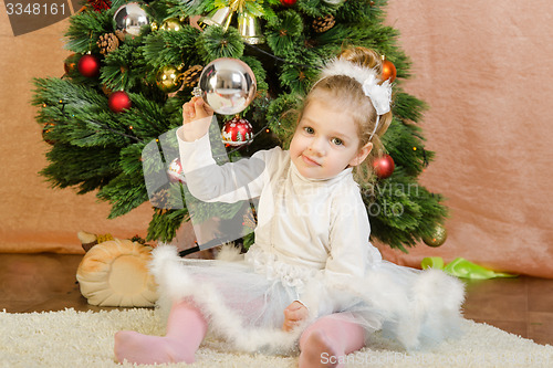 Image of Three year old girl playing Christmas balls