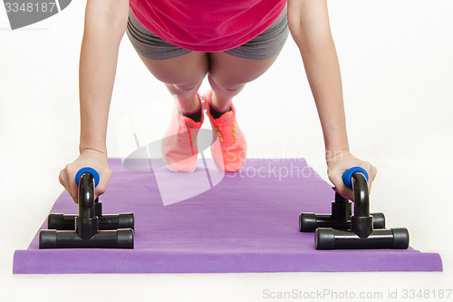 Image of She performs the bench press with help of stops