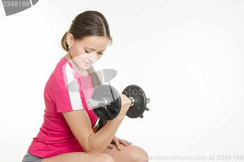 Image of She shakes dumbbell arm muscles