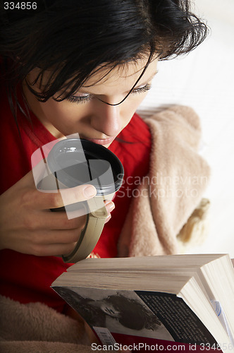 Image of young beautiful woman is reading a book