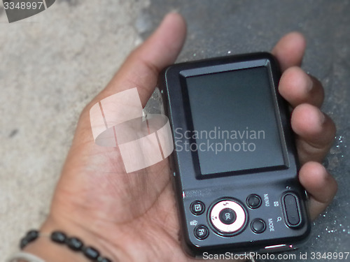 Image of Hand holding digital camera rear view isolate abstract blur background