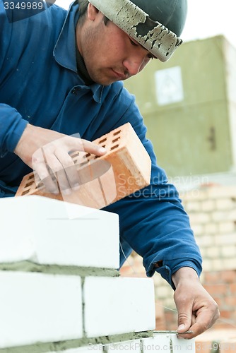 Image of Bricklayer works on house construction