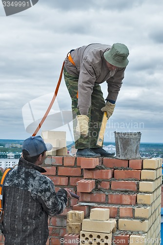 Image of Bricklayers work on high house construction