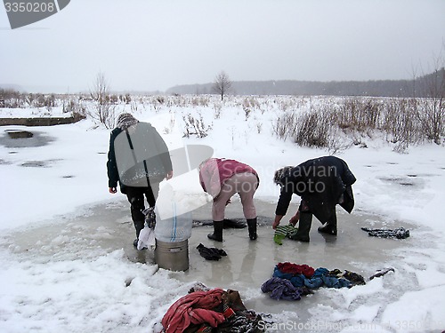 Image of three rural women washing clothes in the ice-hole