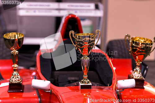 Image of Trophies for winner and red racing car