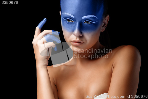 Image of Portrait of a woman who is posing covered with blue paint