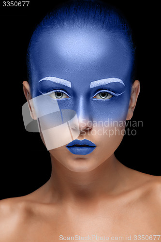 Image of Portrait of a woman who is posing covered with blue paint